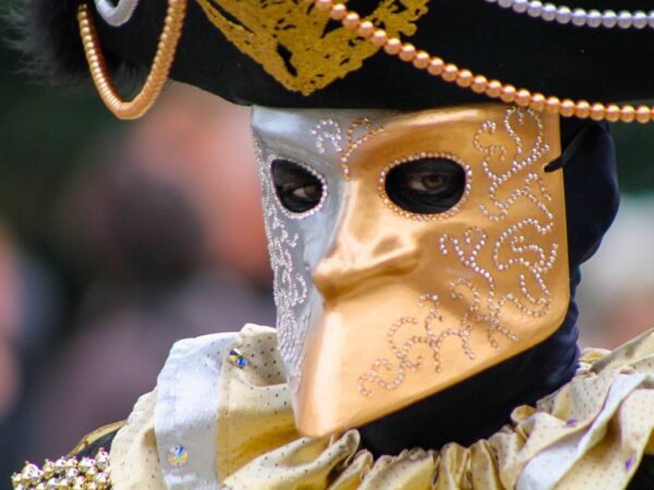 person wearing gold bauta carnival mask