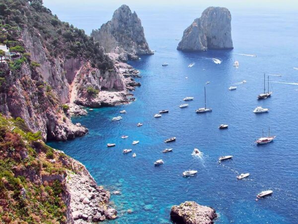 cliffs and sea surrounding capri with lots of boats anchored
