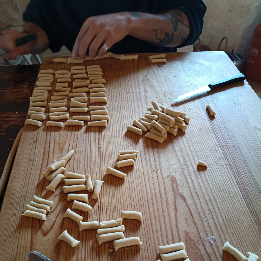 Pasta being shaped on a wooden table