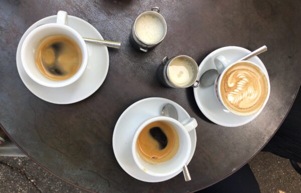 tram depot black coffees, two milk jugs and cappuccino cup