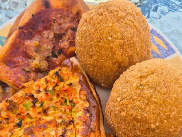 two arancine and slices of savory pizza tart on a plate