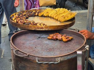 roasting chestnuts over large brazier outdoors